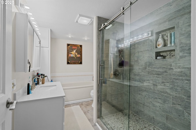 bathroom with toilet, a shower stall, a bath, and vanity