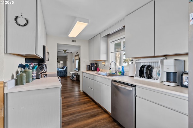 kitchen featuring visible vents, dark wood finished floors, dishwasher, light countertops, and a sink