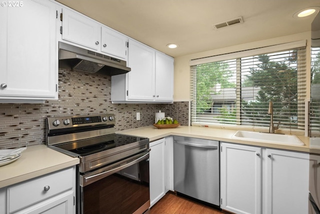 1771 NW 143rd Ave Unit 38, Portland, OR 97229 - kitchen with appliances with stainless steel finishes, under cabinet range hood, light countertops, white cabinetry, and recessed lighting