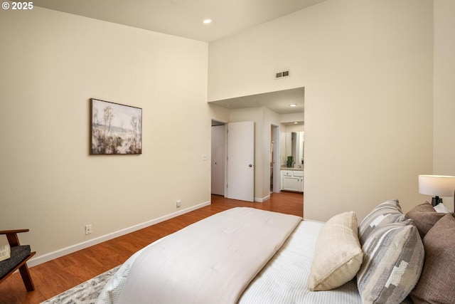 1771 NW 143rd Ave Unit 38, Portland, OR 97229 - bedroom with wood finished floors, a towering ceiling, ensuite bathroom, and recessed lighting
