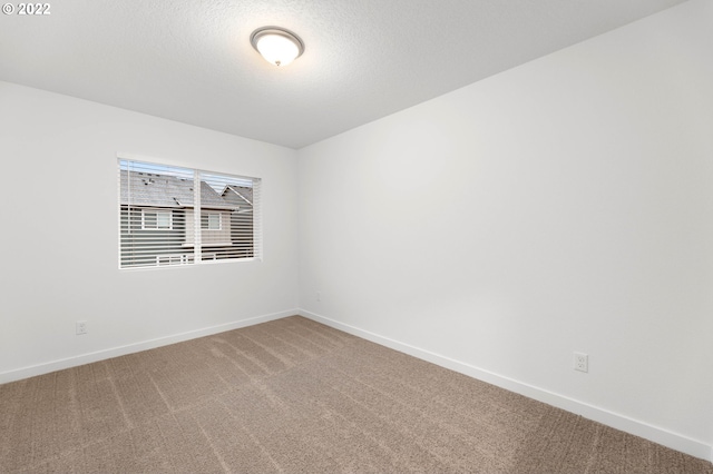 carpeted spare room featuring a textured ceiling