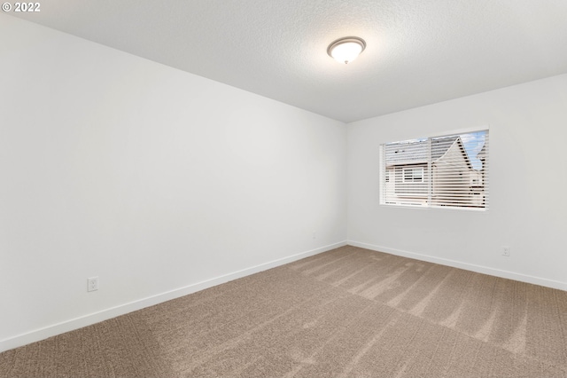 unfurnished room featuring carpet floors and a textured ceiling