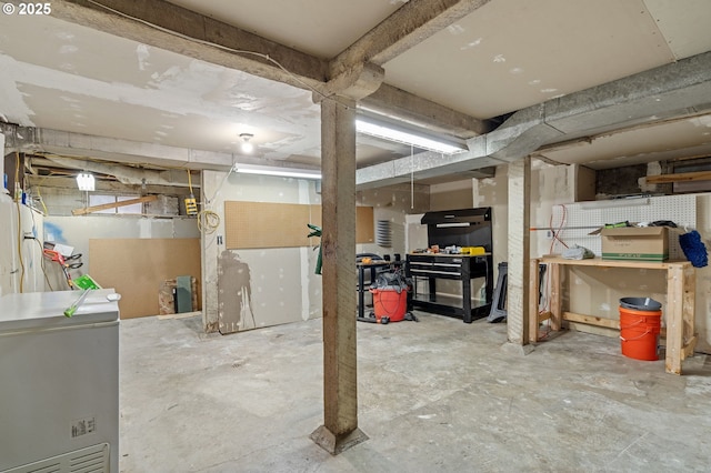 unfinished basement with refrigerator