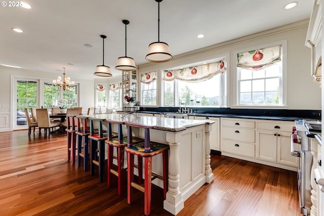 2030 W 34th Ave, Eugene, OR 97405 - kitchen featuring dark wood-style flooring, crown molding, high end stove, a kitchen island, and a chandelier