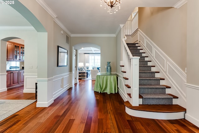 2030 W 34th Ave, Eugene, OR 97405 - stairway featuring wood finished floors, crown molding, a decorative wall, arched walkways, and wainscoting