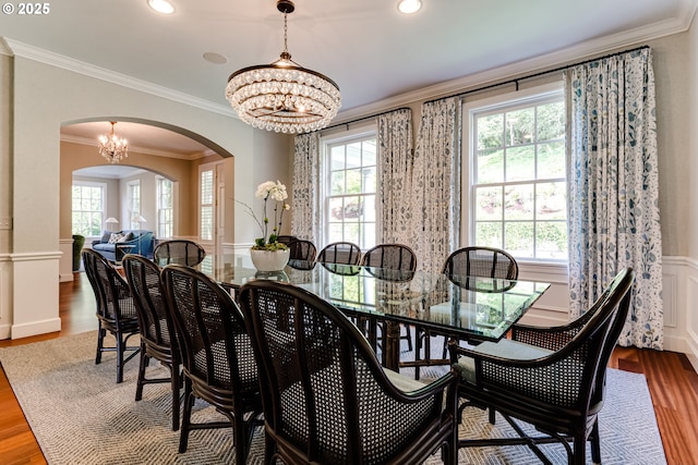 2030 W 34th Ave, Eugene, OR 97405 - dining room featuring arched walkways, healthy amount of natural light, a chandelier, wood finished floors, and a wainscoted wall