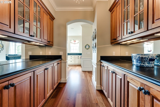 2030 W 34th Ave, Eugene, OR 97405 - kitchen with dark countertops, arched walkways, brown cabinets, dark wood finished floors, and crown molding