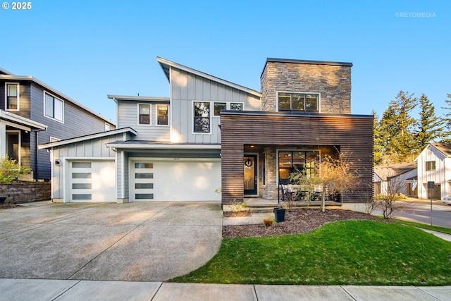 contemporary home featuring driveway, an attached garage, covered porch, stone siding, and board and batten siding