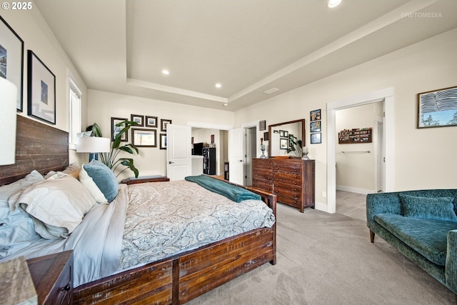 carpeted bedroom with a tray ceiling