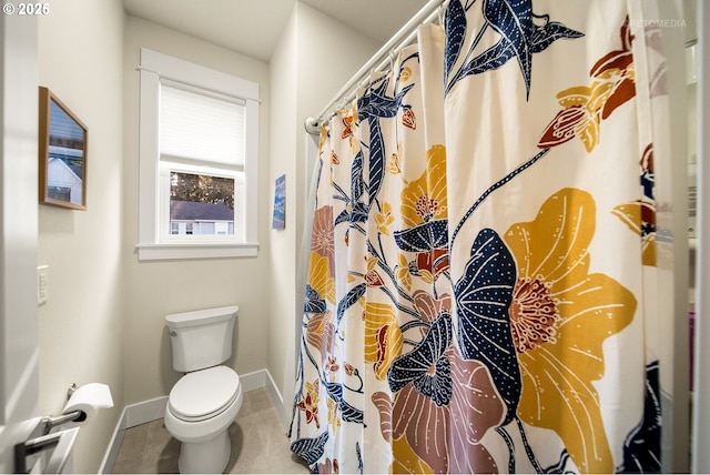 bathroom featuring tile patterned floors, toilet, and walk in shower