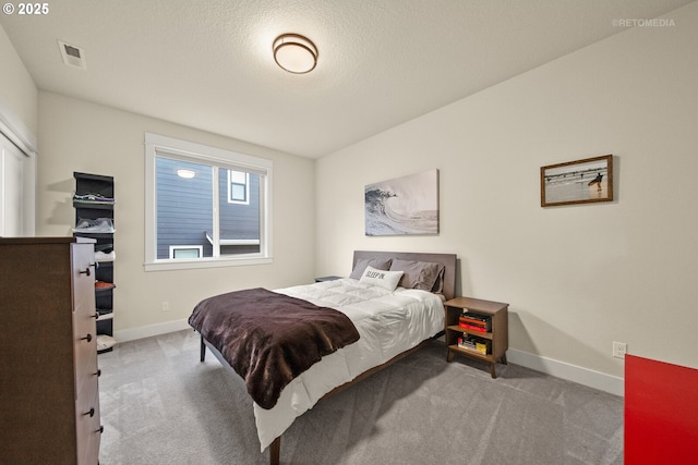 carpeted bedroom with a textured ceiling