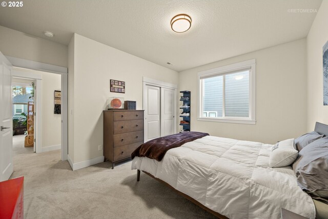 carpeted bedroom with multiple windows, a closet, and a textured ceiling