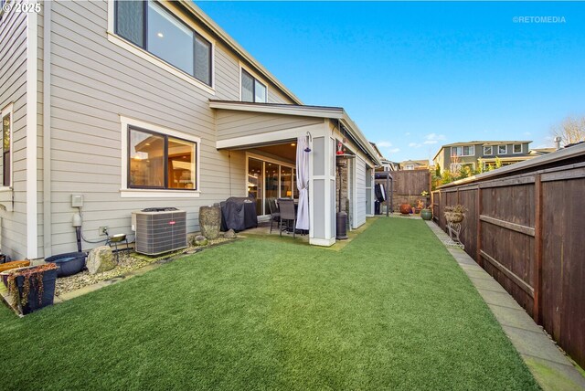 back of house featuring a yard and central AC unit