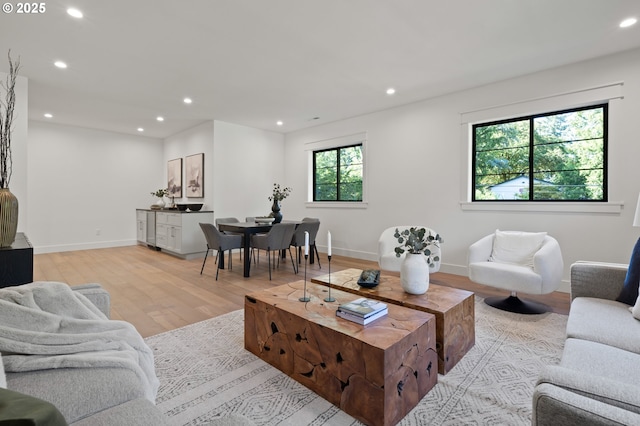 living room with recessed lighting, light wood-type flooring, and baseboards