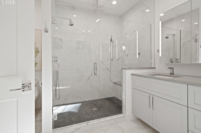 full bathroom featuring marble finish flooring, a marble finish shower, and vanity