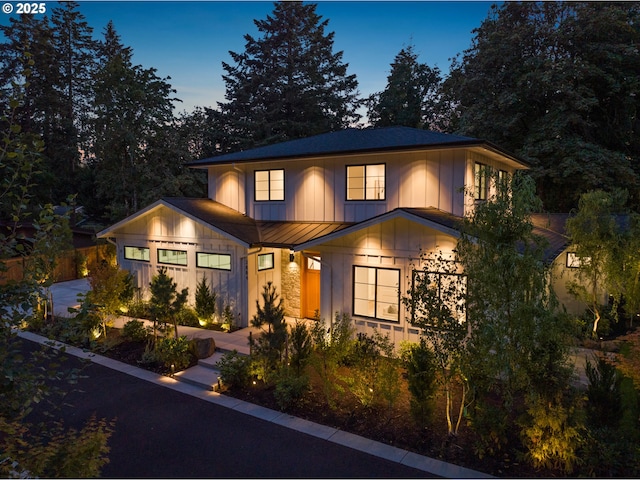 view of front of home with a standing seam roof, metal roof, board and batten siding, and stone siding