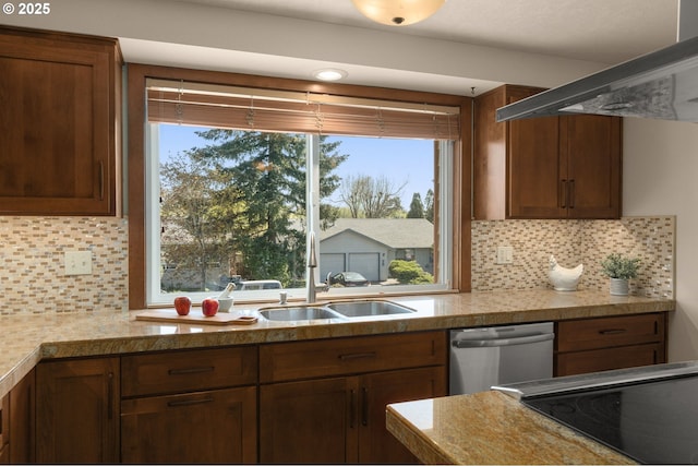 kitchen featuring dishwasher, tasteful backsplash, a sink, and light countertops