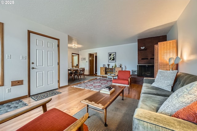 4645 NE 42nd Ave, Portland, OR 97218 - living area featuring wood finished floors, a brick fireplace, and a textured ceiling