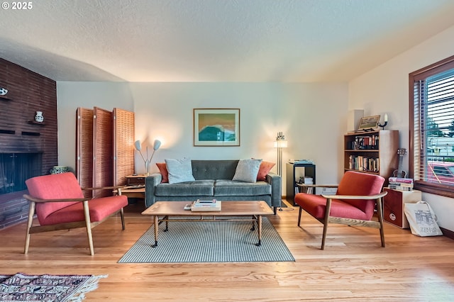 4645 NE 42nd Ave, Portland, OR 97218 - living area with wood finished floors, a fireplace, and a textured ceiling