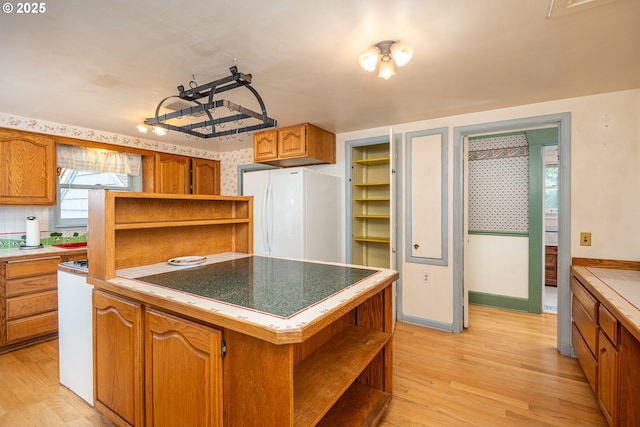 2822 Crocker Rd, Eugene, OR 97404 - kitchen featuring open shelves, freestanding refrigerator, light wood-type flooring, and brown cabinetry