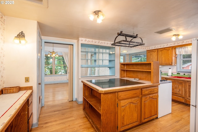 2822 Crocker Rd, Eugene, OR 97404 - kitchen featuring open shelves, light wood-style floors, and brown cabinetry