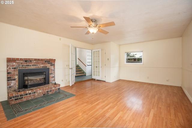 2822 Crocker Rd, Eugene, OR 97404 - unfurnished living room with wood finished floors, a ceiling fan, stairway, and a brick fireplace