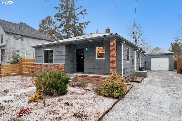 view of front of home featuring a garage and an outbuilding