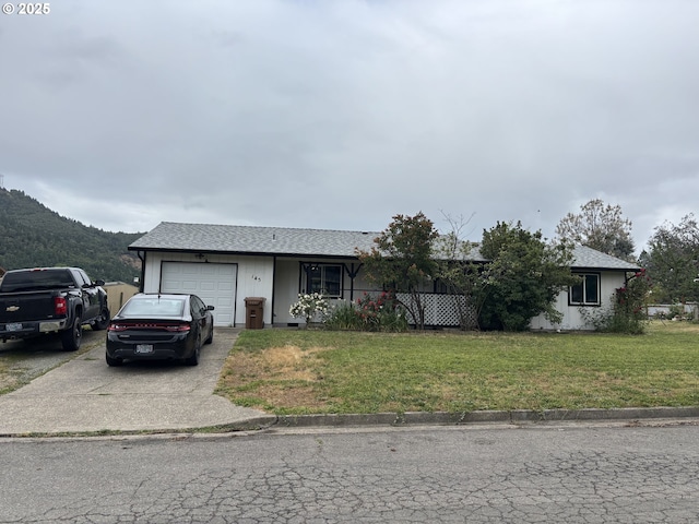 145 Donald Ter, Myrtle Creek, OR 97457 - view of front facade featuring an attached garage, a front yard, concrete driveway, and a mountain view