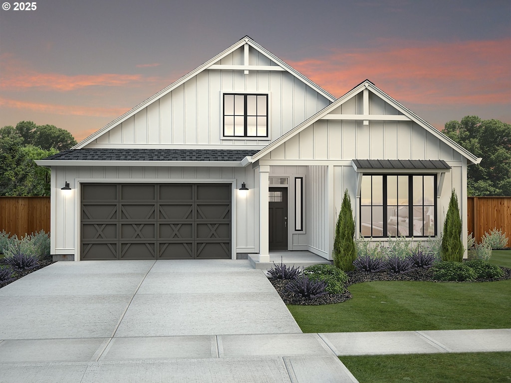 view of front of property featuring a garage and a lawn