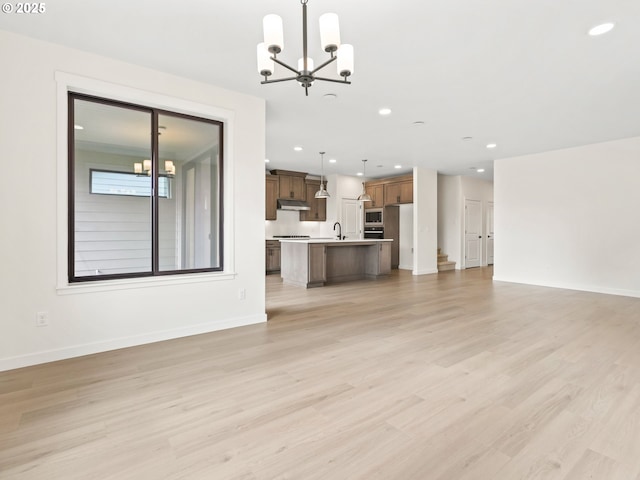17019 NE 82nd St, Vancouver, WA 98682 - unfurnished living room featuring baseboards, recessed lighting, light wood-type flooring, and an inviting chandelier