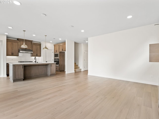 17019 NE 82nd St, Vancouver, WA 98682 - kitchen with light countertops, appliances with stainless steel finishes, light wood-style floors, open floor plan, and under cabinet range hood