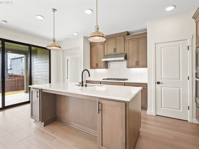 17019 NE 82nd St, Vancouver, WA 98682 - kitchen with backsplash, a sink, under cabinet range hood, and light wood finished floors