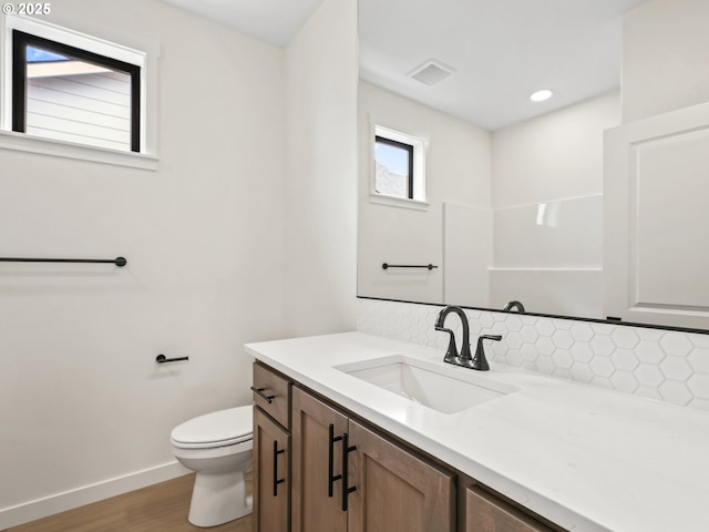17019 NE 82nd St, Vancouver, WA 98682 - bathroom featuring toilet, wood finished floors, vanity, visible vents, and decorative backsplash