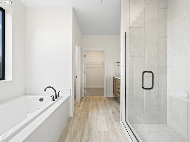 17019 NE 82nd St, Vancouver, WA 98682 - bathroom featuring a garden tub, wood finished floors, vanity, a shower stall, and a walk in closet