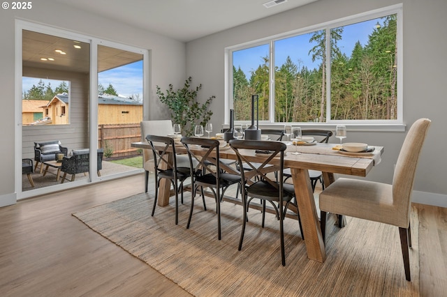 dining space featuring visible vents, baseboards, and wood finished floors