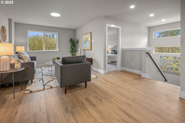 living area with a wealth of natural light, baseboards, and wood finished floors