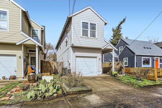 view of front of property featuring an attached garage, concrete driveway, and fence