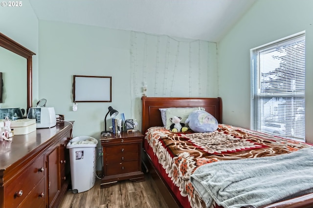 bedroom featuring lofted ceiling and wood finished floors