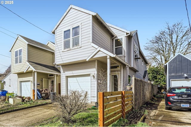 traditional-style home featuring a garage, concrete driveway, and fence