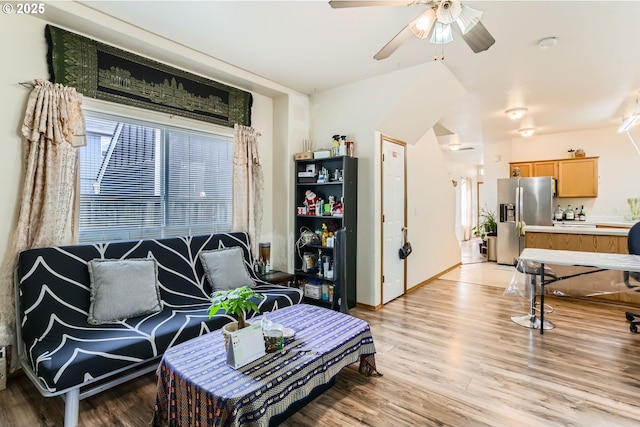 sitting room with a ceiling fan, baseboards, and light wood finished floors