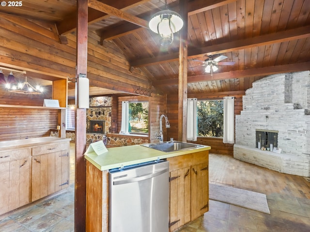 kitchen with sink, lofted ceiling with beams, dishwasher, pendant lighting, and an outdoor stone fireplace