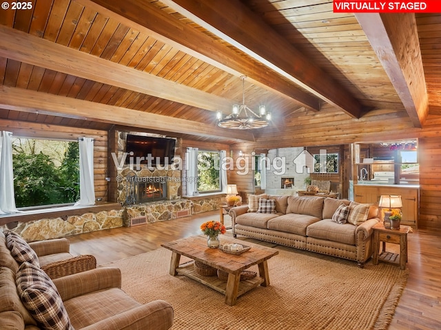 living room with hardwood / wood-style flooring, an inviting chandelier, a fireplace, lofted ceiling with beams, and wooden ceiling