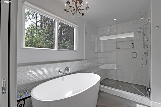 7100 SW Willowmere Dr, Portland, OR 97225 - bathroom with healthy amount of natural light, a stall shower, tile patterned floors, a soaking tub, and tile walls