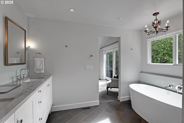 7100 SW Willowmere Dr, Portland, OR 97225 - full bath with healthy amount of natural light, a freestanding tub, double vanity, a chandelier, and recessed lighting