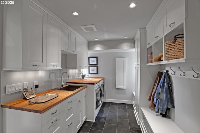 7100 SW Willowmere Dr, Portland, OR 97225 - laundry room with washer and dryer, recessed lighting, baseboards, and dark marble finish floors