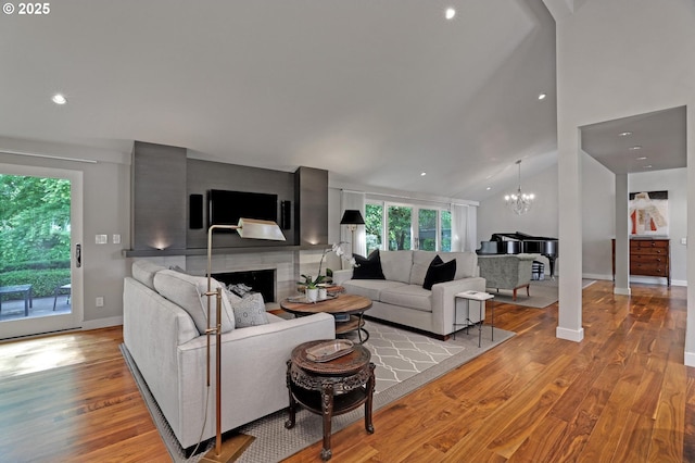 7100 SW Willowmere Dr, Portland, OR 97225 - living room featuring light wood-style flooring, lofted ceiling, recessed lighting, a fireplace, and a chandelier