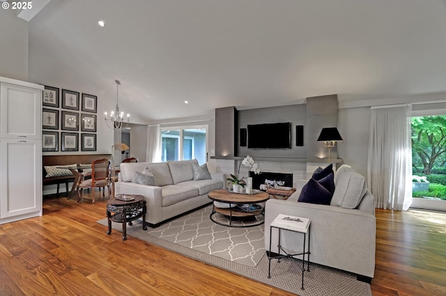 7100 SW Willowmere Dr, Portland, OR 97225 - living area featuring a chandelier, healthy amount of natural light, wood finished floors, and lofted ceiling