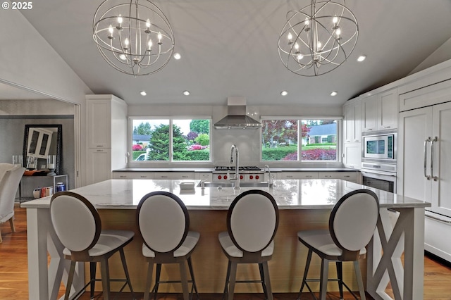 7100 SW Willowmere Dr, Portland, OR 97225 - kitchen with a chandelier, appliances with stainless steel finishes, wall chimney exhaust hood, vaulted ceiling, and healthy amount of natural light