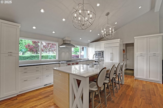 7100 SW Willowmere Dr, Portland, OR 97225 - kitchen featuring range hood, a sink, a chandelier, light wood-style floors, and recessed lighting