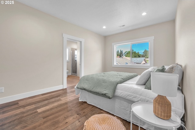 bedroom with hardwood / wood-style flooring and ensuite bathroom